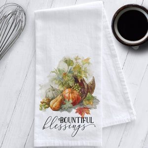 Flour sack tea towel with watercolor cornucopia art, featuring pumpkins, gourds, fall leaves, and the phrase "Bountiful Blessings."
