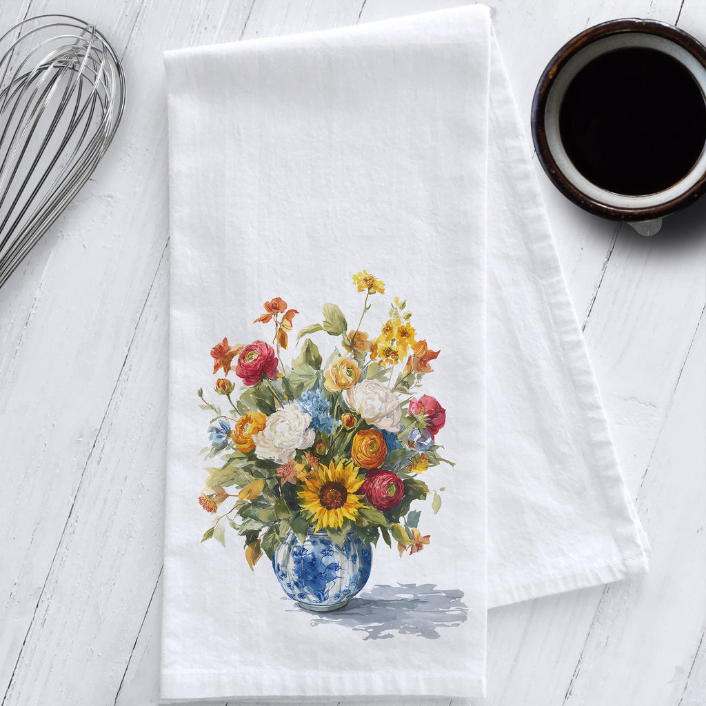 White flour sack tea towel featuring vibrant fall watercolor flowers in a blue and white chinoiserie vase; styled on white kitchen counter.