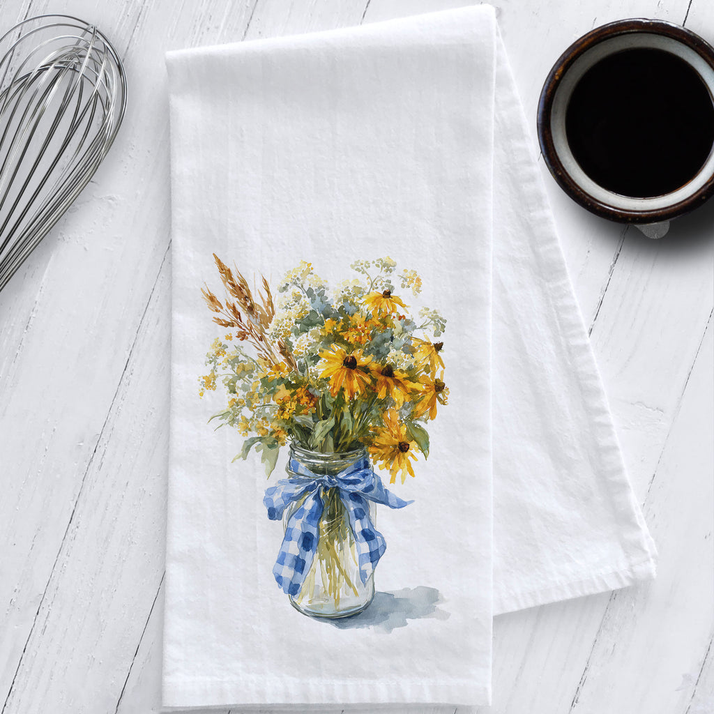 Cotton flour sack tea towel featuring watercolor art of wildflowers and Black Eyed Susans in a mason jar with a blue gingham bow.