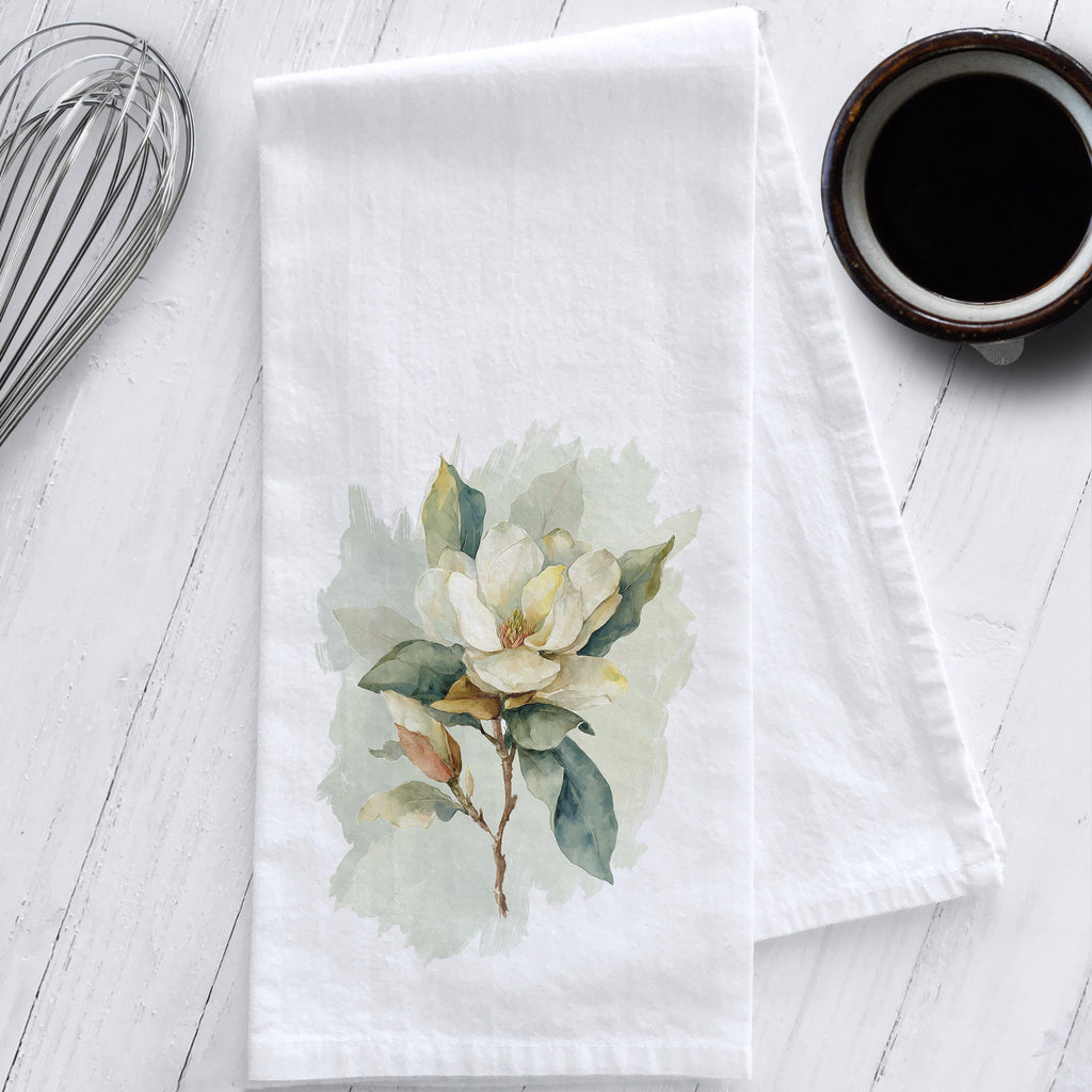 White cotton flour sack tea towel with watercolor magnolia flower design, southern farmhouse kitchen decor by Studio 901 Goods.